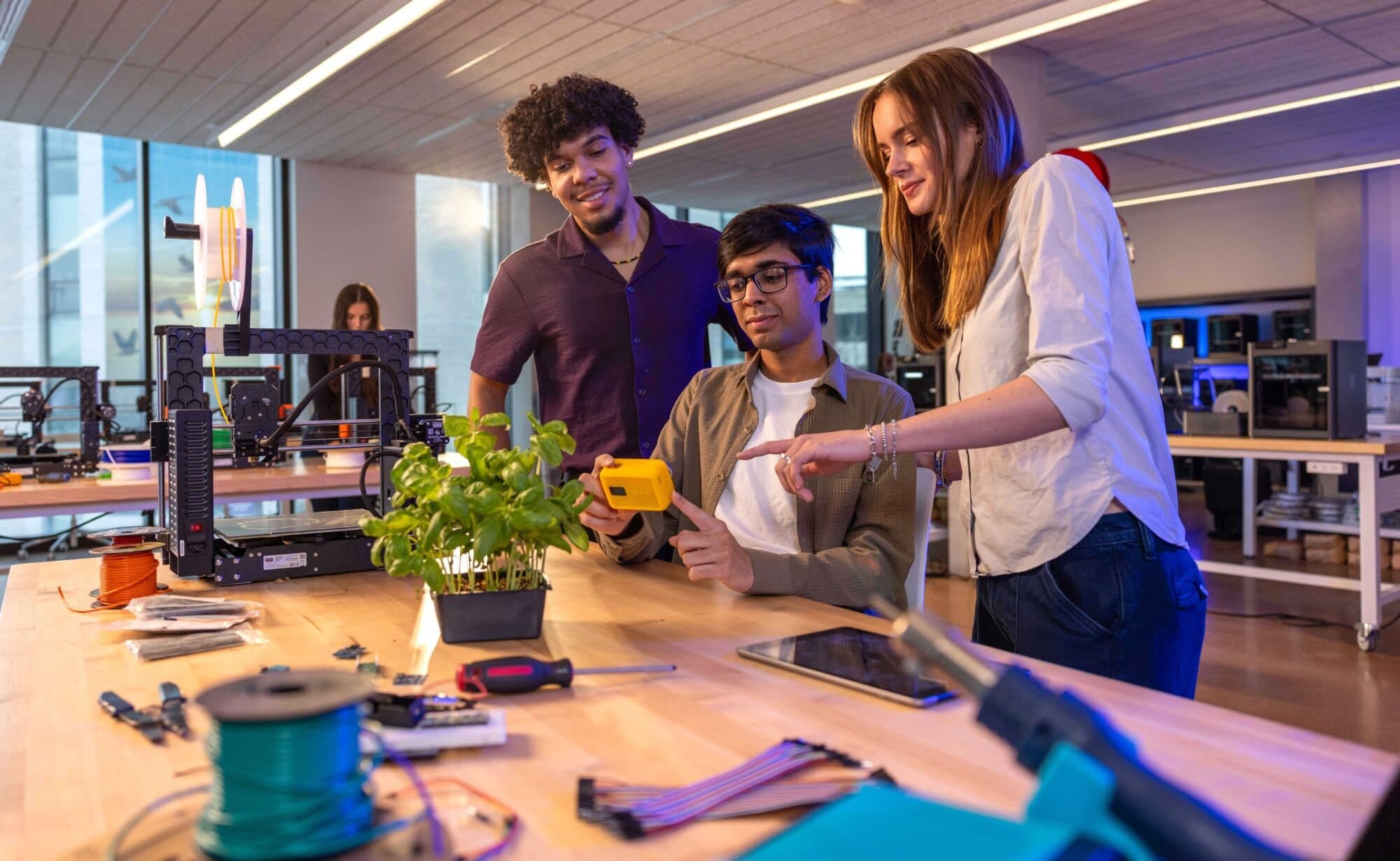 Kalan Roye, Aakarsh Garg, and Branka Verhoeven reviewing a prototype in the digital makerspace